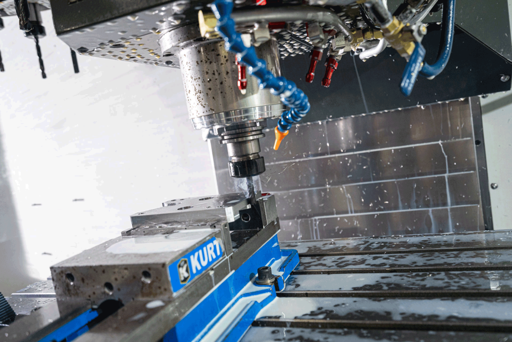 A water-cooled drill bores into a block of metal.