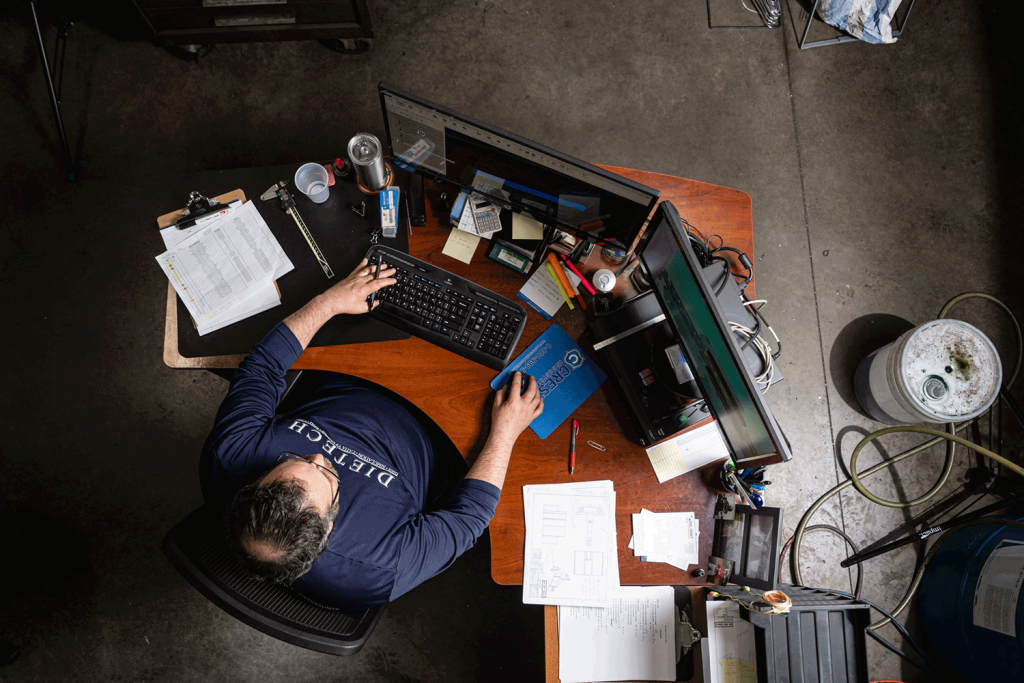 An overhead view of a man working at his desk.