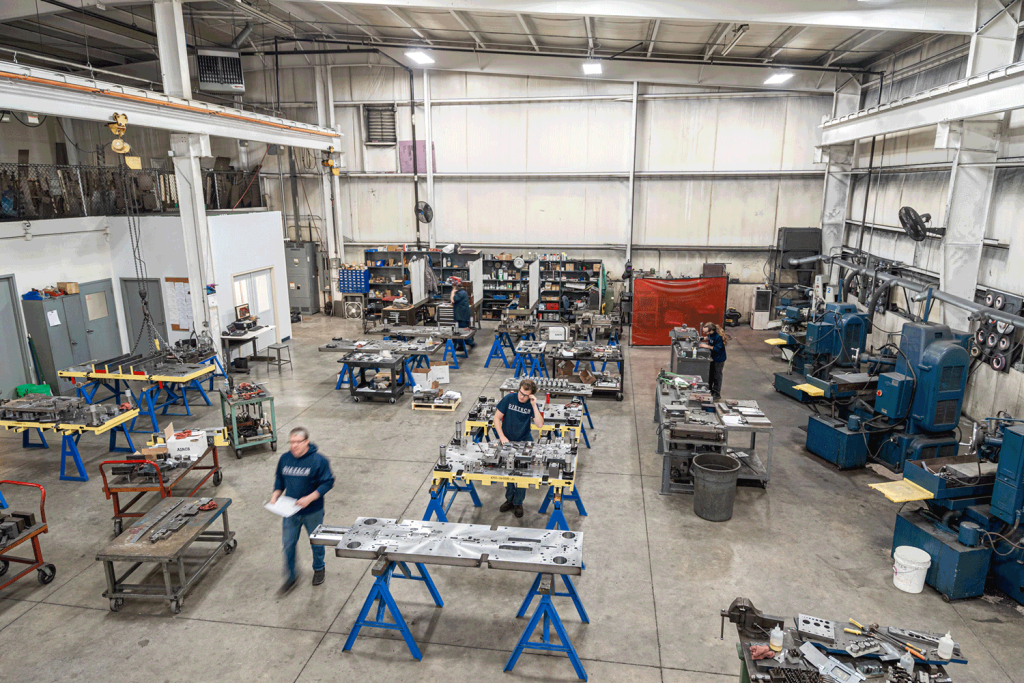 A view of the tooling and die making department with various workers going on about their dutues.