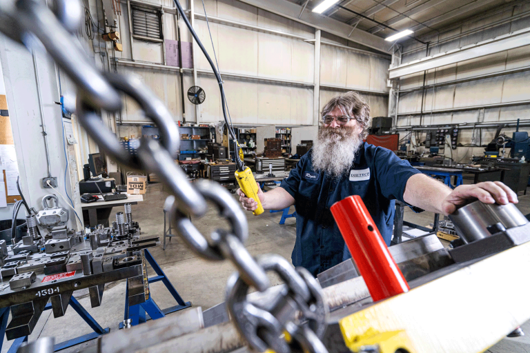A machine being operated by a man with a beard and glasses.