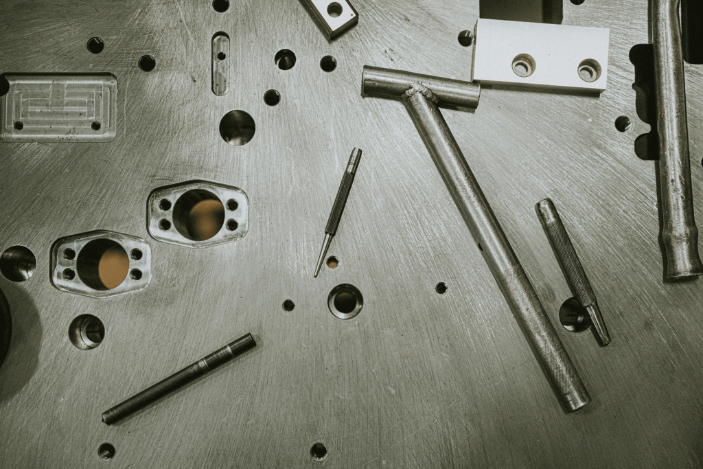 A metal plate displaying various tools and screws arranged neatly on its surface.