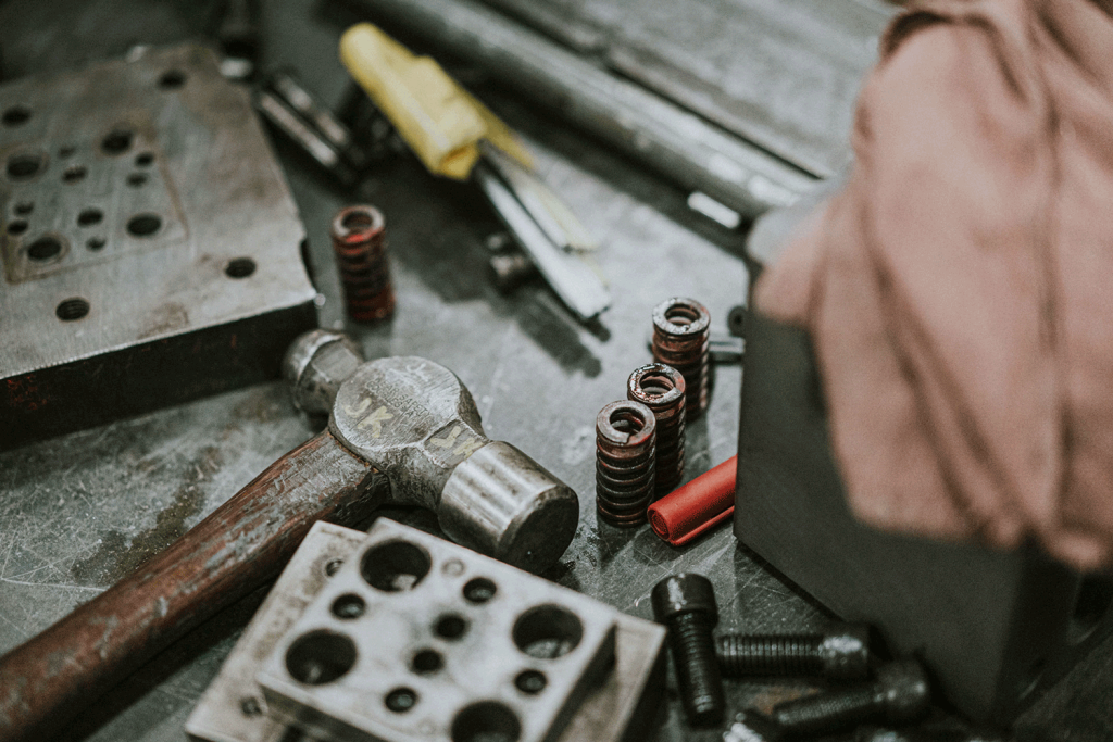 A diverse assortment of die making tools and equipment neatly arranged on a table, ready for use.