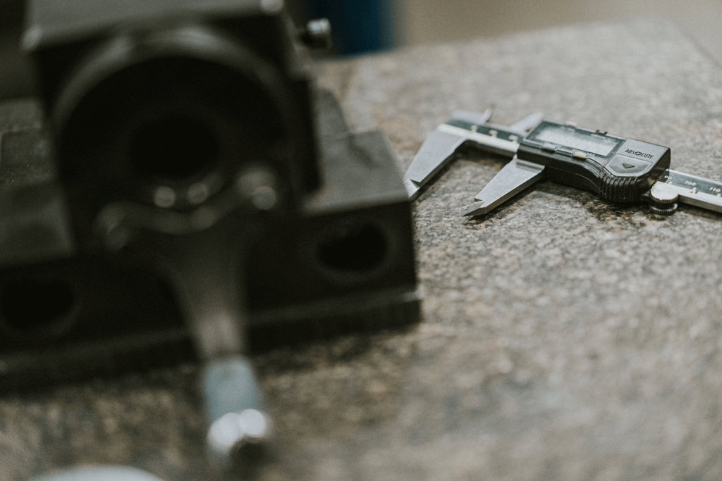 A table displaying a pair of calipers and a wrench, essential tools for precise measurements and mechanical adjustments.
