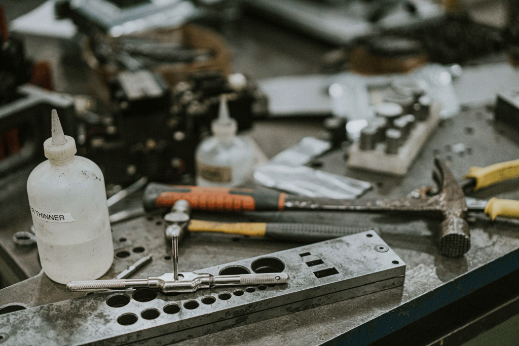A table displaying hammers, solvents and other die making tools.