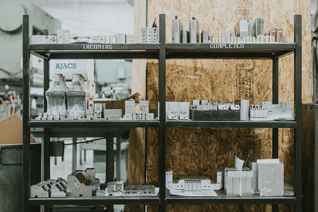 A shelving unit full of incoming and completed machine parts.