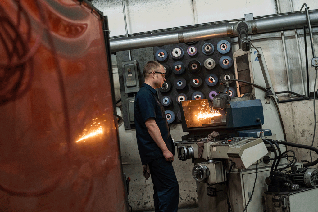 A man operating a grinder in a factory, ensuring efficient production processes.