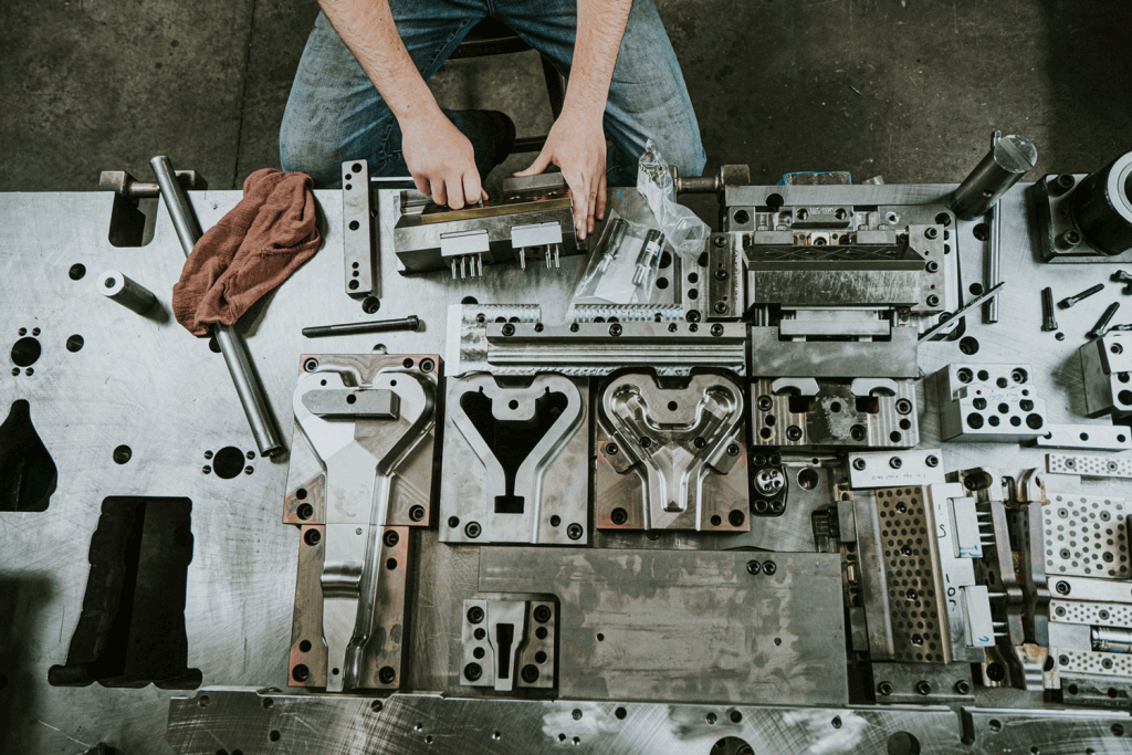 A pair of hands working on various stamping tools.