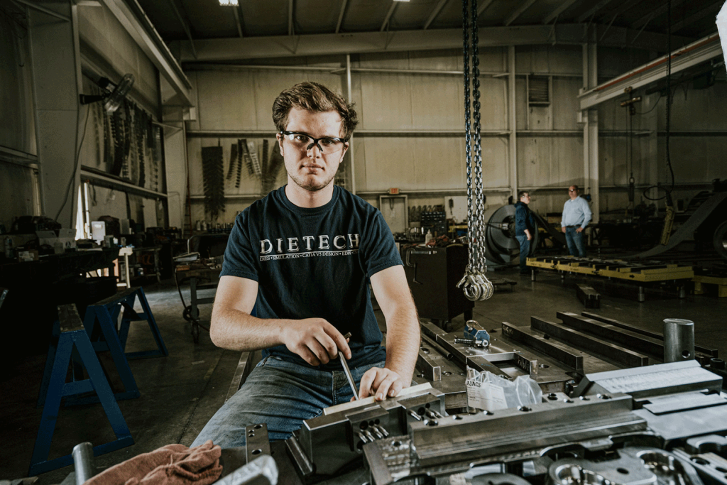 An individual in a black shirt working on equipment.